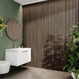 product lifestyle image of Camden Walnut and Black Waterproof Slatted Wall Panels in bathroom with wall hung vanity unit, round mirror and pot plant SAN104